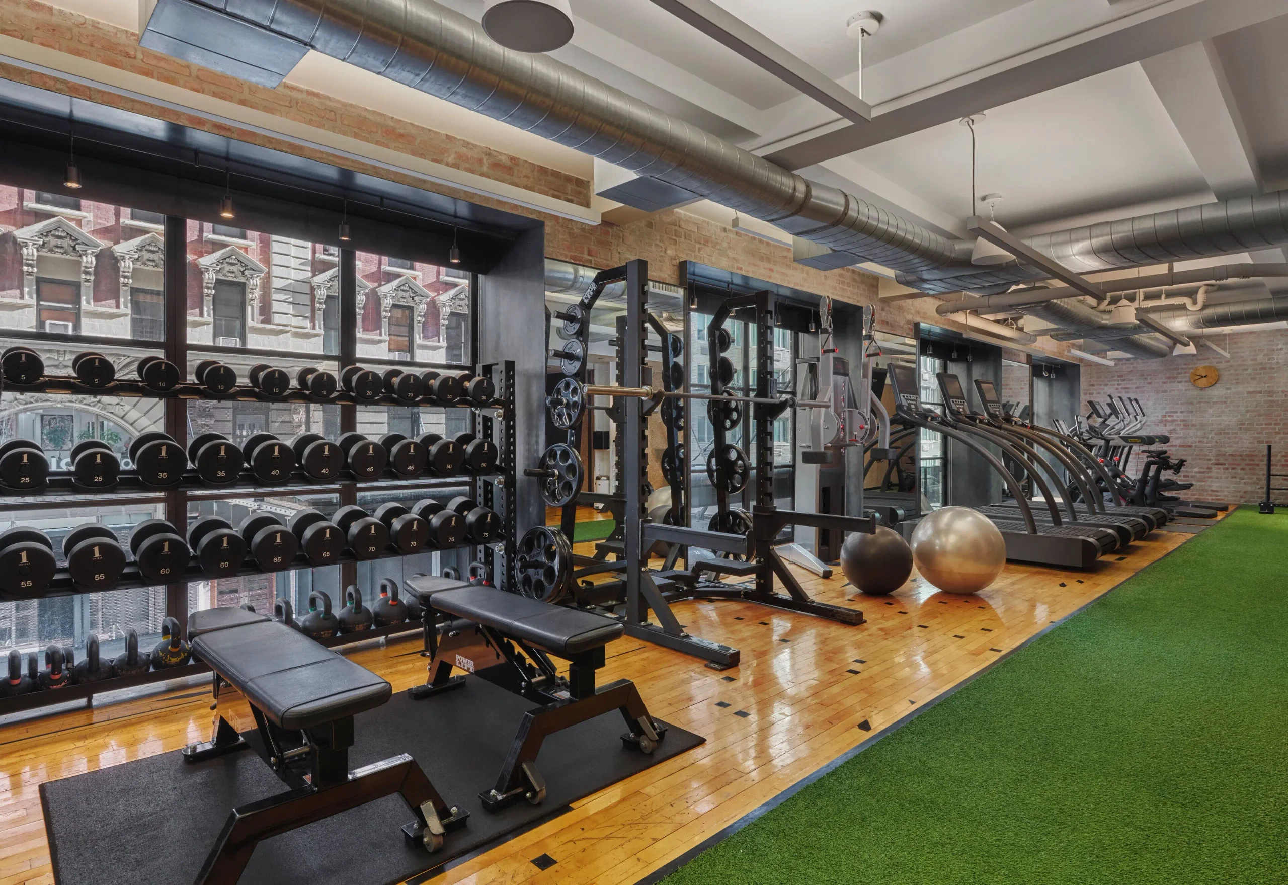 24-hour Field House gym at 1 Hotel Central Park with Peloton bikes and reclaimed wood floor