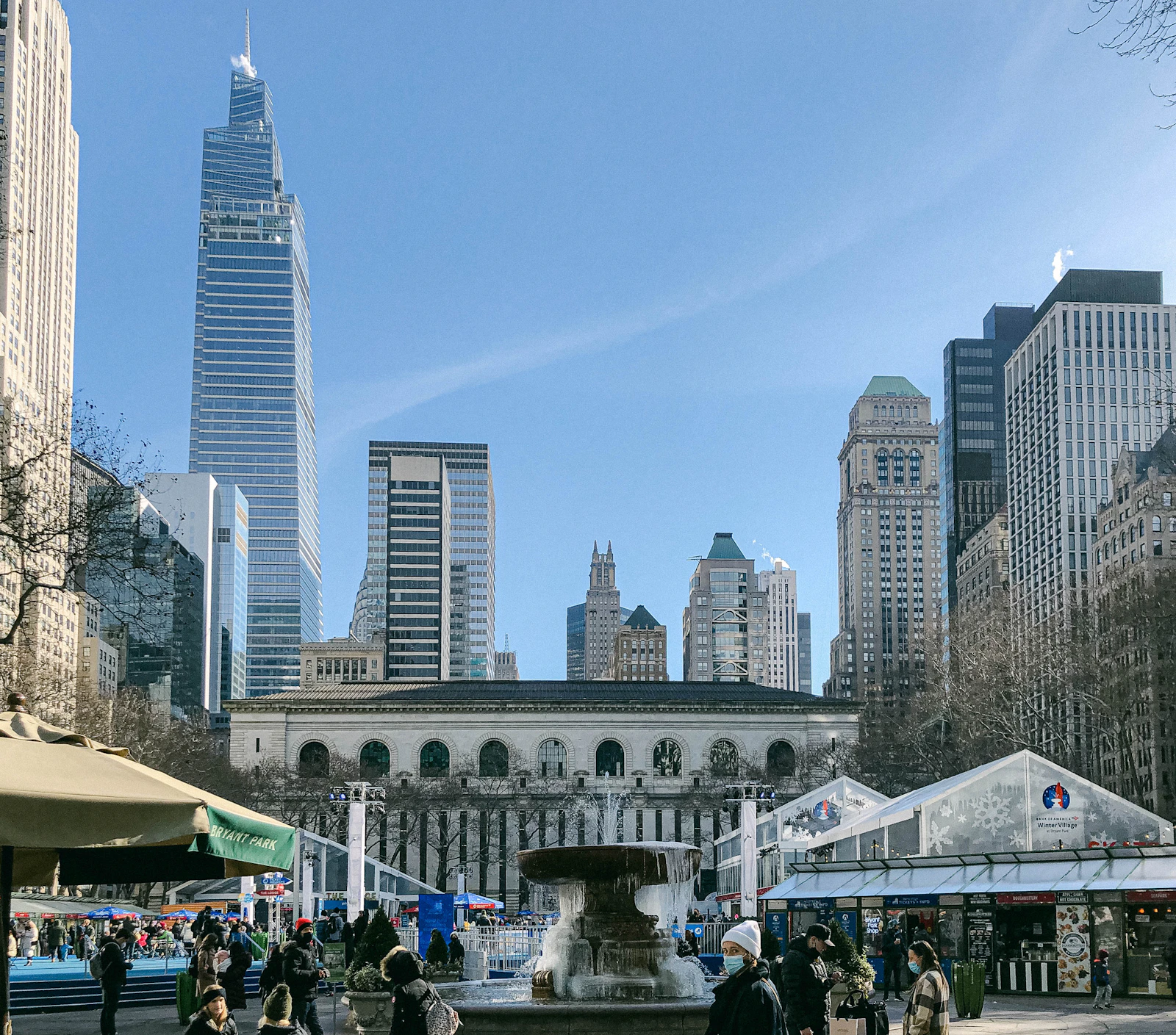 Bryant Park lawn with holiday market tents and the New York Public Library behind it