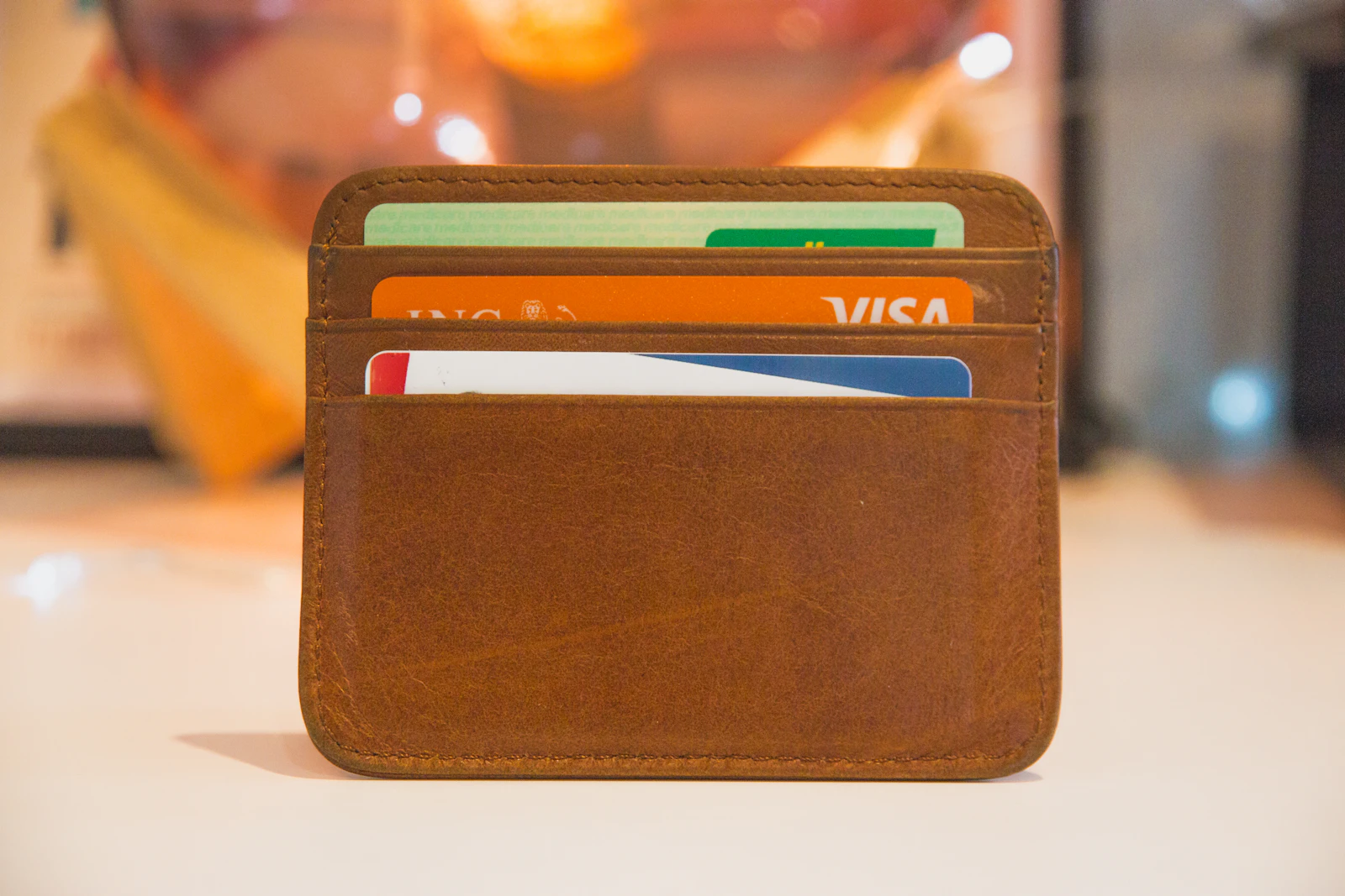 A brown leather card wallet holding several credit cards