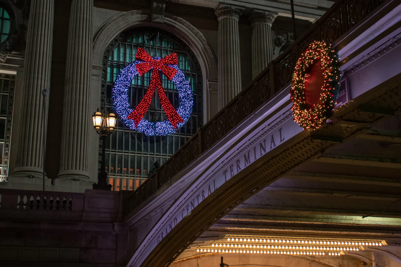 Large holiday wreaths with red bows hanging inside Grand Central Terminal