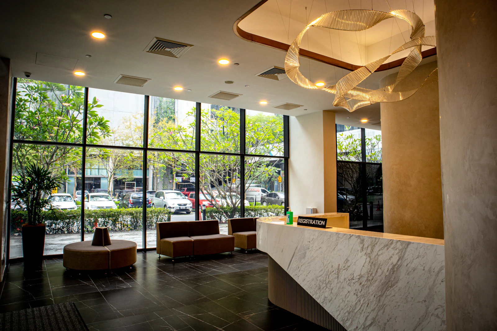 A hotel lobby with a marble reception counter and large windows