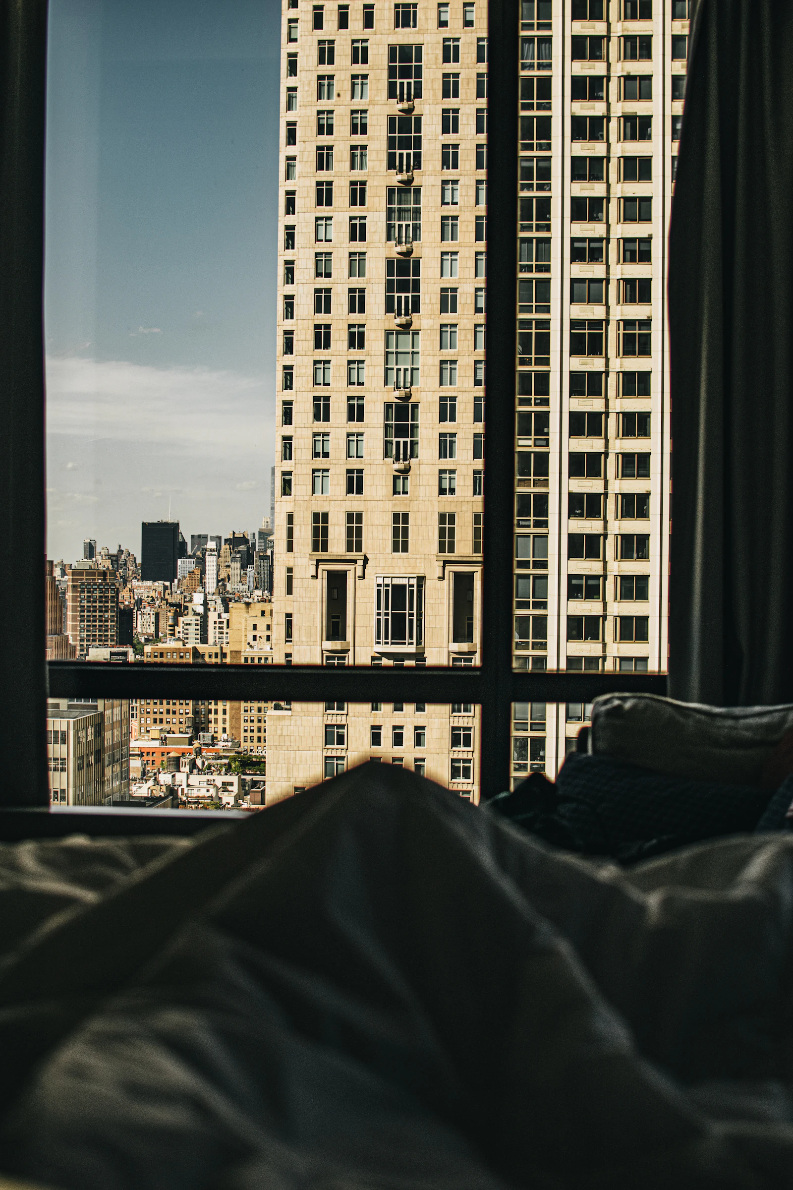 Manhattan apartment towers seen through a high-floor hotel bedroom window