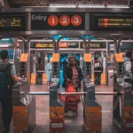 Riders passing through turnstiles at a New York subway station entrance