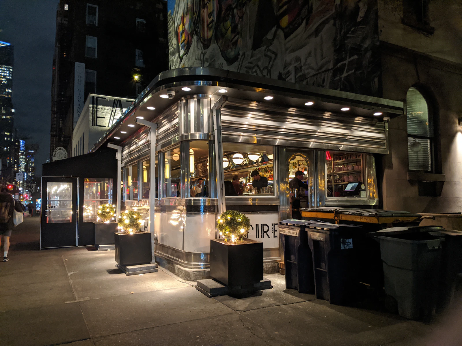 A brightly lit corner diner on a quiet city street at night