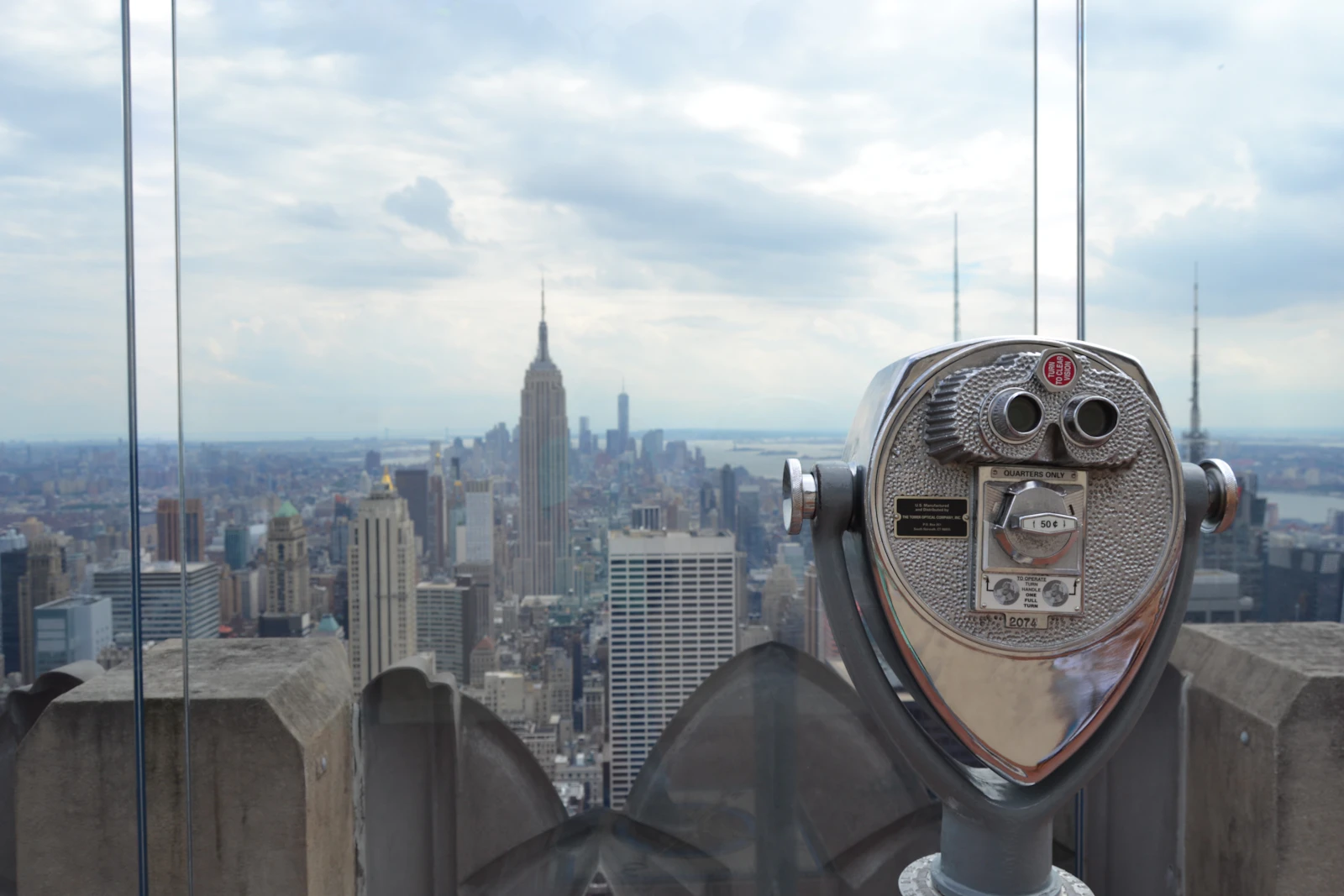 Coin-operated binoculars on an observation deck facing the Manhattan skyline and the Empire State Building
